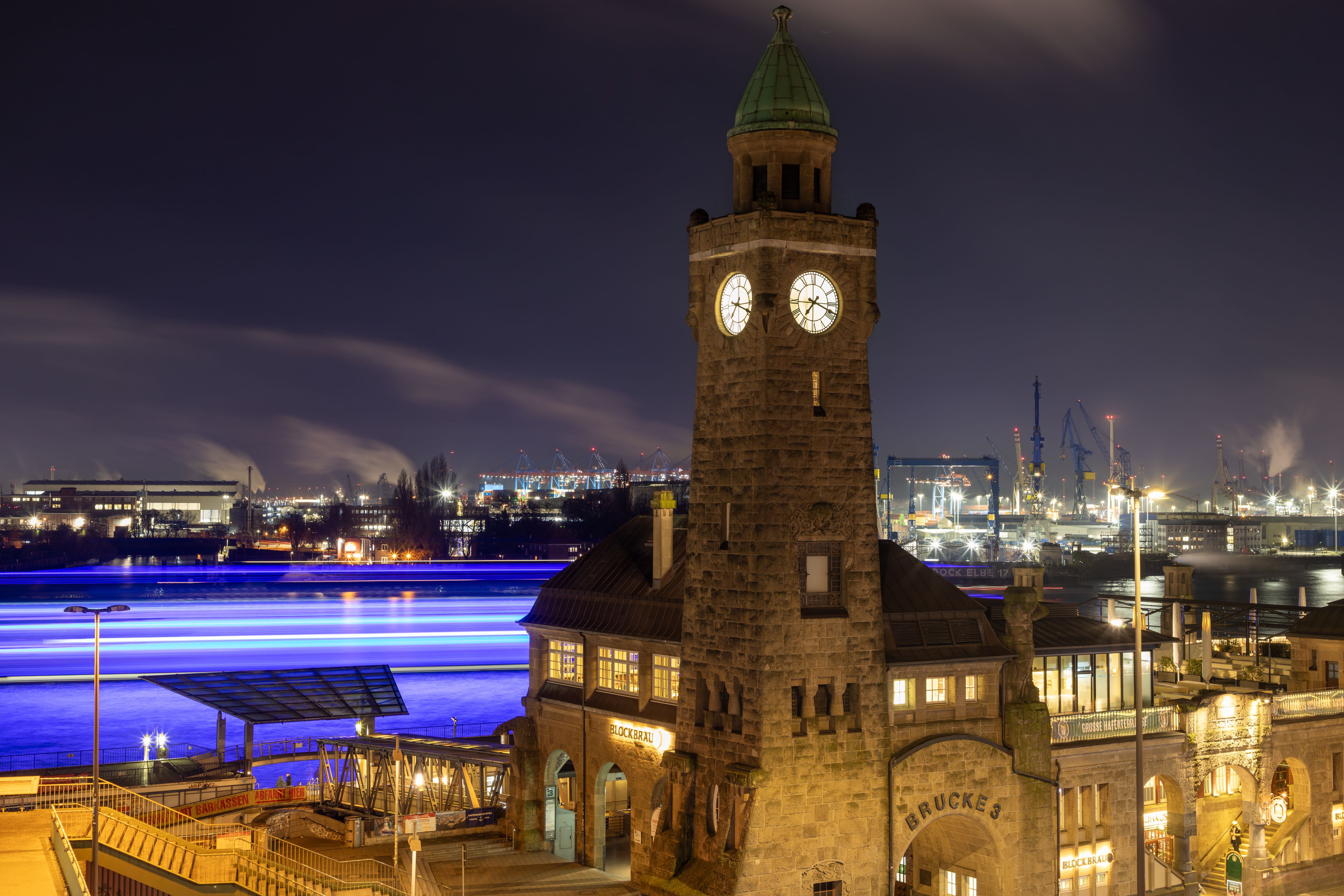 Hamburger Pegelturm vor Hafenlichtern in der blauen Stunde