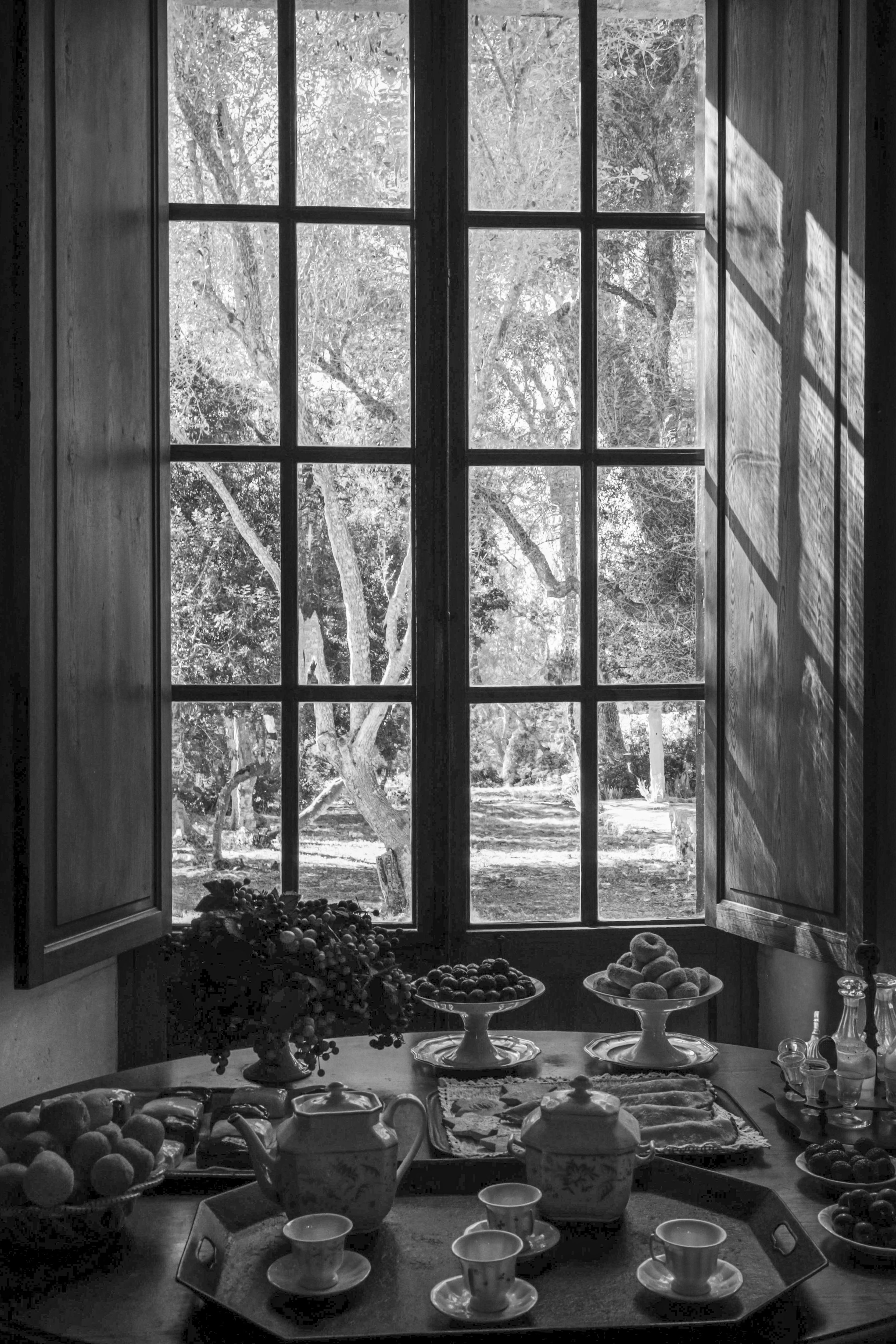 Gedeckter Tisch im Schatten eines hohen Fensters